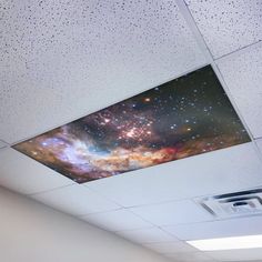 the ceiling in an office space with a painting on it's side and a window to the other side