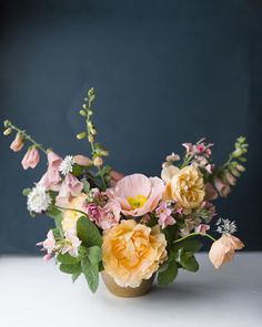 a vase filled with lots of flowers on top of a table