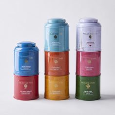 four different colored canisters stacked on top of each other