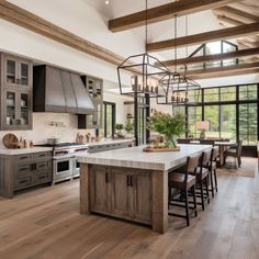 a large kitchen with wooden floors and gray cabinets