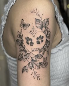 a woman's arm with a heart and flowers tattooed on the back of her shoulder