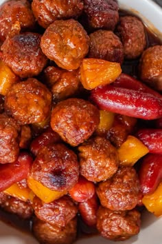 a white bowl filled with meatballs and fruit