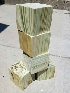 several pieces of wood stacked on top of each other in front of a sidewalk area