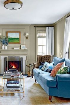 a living room filled with furniture and a fire place in the middle of a room