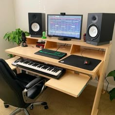 a desk with a keyboard, monitor and speakers on it