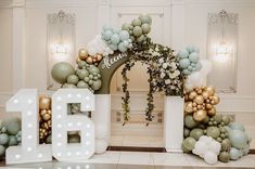 an entrance decorated with balloons and greenery in the shape of letters that spell out b is for b is for b