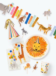 an assortment of children's party decorations including paper animals and giraffes