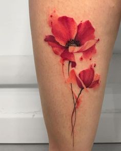 a woman's leg with red flowers painted on the side and watercolors