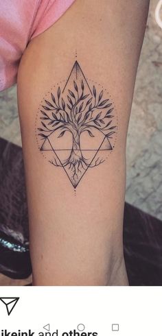 a small tree tattoo on the right side of the thigh, with triangles and leaves