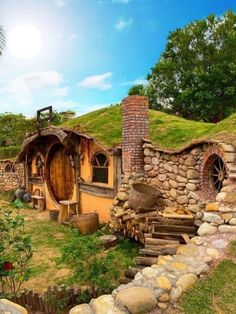 an image of a hobbot house in the middle of grass and rocks with stairs leading up to it