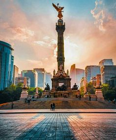 the sun is setting in front of a monument