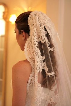 a woman wearing a wedding veil in front of a mirror