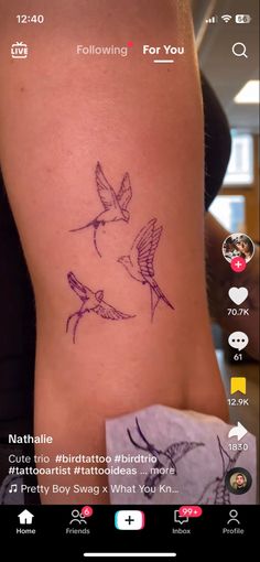 a small tattoo on the side of a woman's leg, with birds flying around it