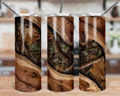 three stainless steel tumblers with wood designs on them