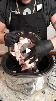 a man in black shirt and gloves preparing food