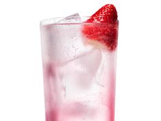 a tall glass filled with ice and strawberries