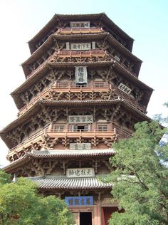 a tall building with lots of windows on it's side and trees in the foreground