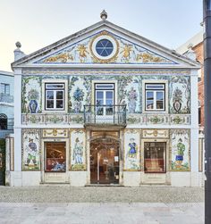 an ornate building with many windows on the front and second story is painted in blue, gold and white