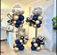 two tall balloons with bows on them are decorated in gold and blue