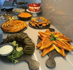 a table topped with lots of different types of cakes and pies on top of plates