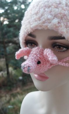 a mannequin wearing a knitted hat with a pink pig on it's nose