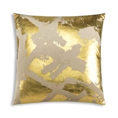 a gold and silver pillow on a white background with an abstract design in the middle