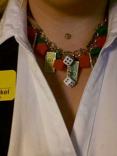 a close up of a person wearing a necklace with dice on it