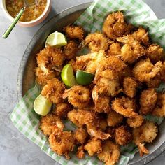 a plate full of fried food next to a bowl of dipping sauce