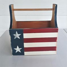 an american flag painted wooden box on a white table with wood slats in the background