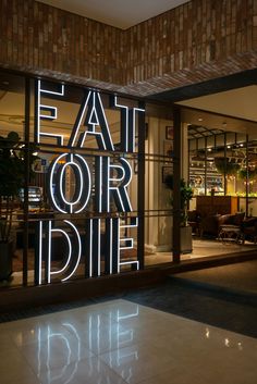 a neon sign that reads eat our die