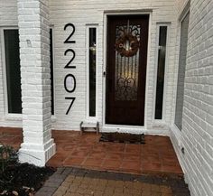 a front door with the number 2077 painted on it and a wreath in the window