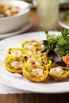 some food is on a white plate with garnishes and vegetables in the background