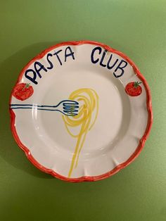 a plate with the words pasta club written on it and strawberries sitting on top