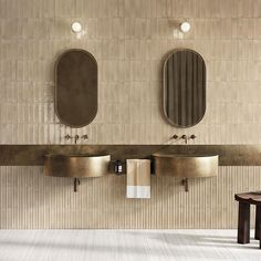 two sinks and mirrors in a bathroom with white flooring, beige tile walls and wooden stools