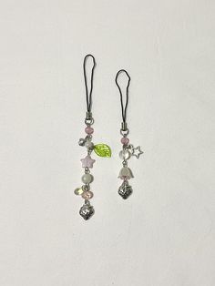 two pairs of earrings with charms hanging from them