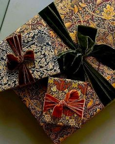 two wrapped gift boxes with bows on them