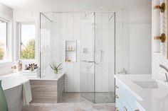 a bathroom with a walk in shower next to a white bathtub and sink under a window