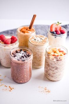 four jars filled with different types of desserts on a table next to each other