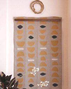 a potted plant sitting on top of a wooden shelf next to a wall hanging