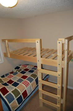 a bunk bed with a ladder next to it and a quilt on the bottom floor