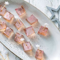 small desserts are arranged on a plate with toothpicks and star shaped decorations