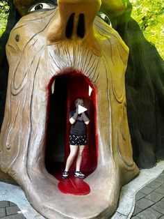 a woman standing in the entrance to a fake tree house