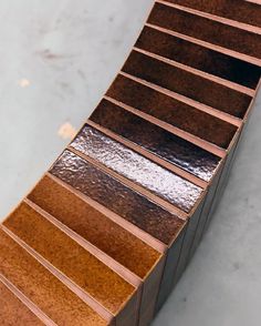 a close up of a wooden bench made out of plywood planks and metal strips