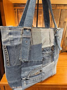 a bag made out of jeans sitting on top of a wooden table