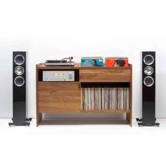 a record player sitting on top of a wooden shelf next to a stereo and speakers