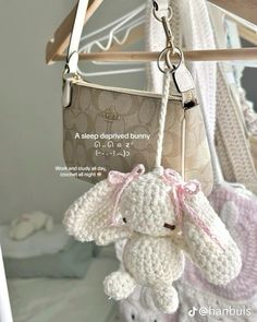 a crocheted stuffed animal hanging from a wooden rack next to a handbag