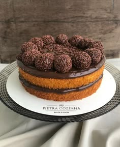 a cake with chocolate frosting and sprinkles sitting on top of a white plate