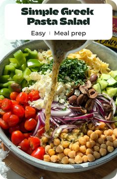 a bowl filled with vegetables and pasta being drizzled on top of it