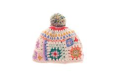 a multicolored crocheted hat with pom - pom