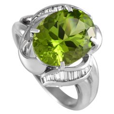 Green, glistening, and gorgeous. This platinum ring stands out with its 4.92-carat peridot center stone supported by a split shank. Swirling channels of tapered baguette diamonds give this breathtaking peridot ring a whimsical finish. The ring's top dimensions measure 17mm by 17mm.This Platinum 0.25 ct Diamond and 4.92 ct Peridot Ring is offered in estate condition and comes with a gift box. Judith Ripka Ring, Diamond Eternity Wedding Band, White Gold Set, Diamond Ring Settings, Citrine Ring, Peridot Ring, Modern Ring, Eternity Ring Diamond, Diamond Rings Bands